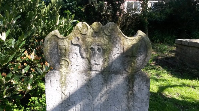 This headstone from 1752 has both the death head and hourglass symbols on it.
